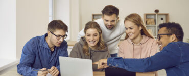 University students using a laptop computer while working on their group project