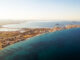 Aerial picturesque panoramic horizontal image, drone point of view La Manga del Mar Menor townscape and seaside spit of turqiouse Mediterranean Sea. Murcia, Spain. Travel and holidays concept
