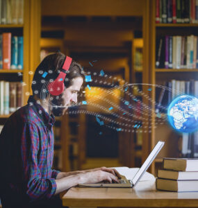 Composition of digital globe over male student using laptop in library. global education, digital interface, technology and networking concept digitally generated image.